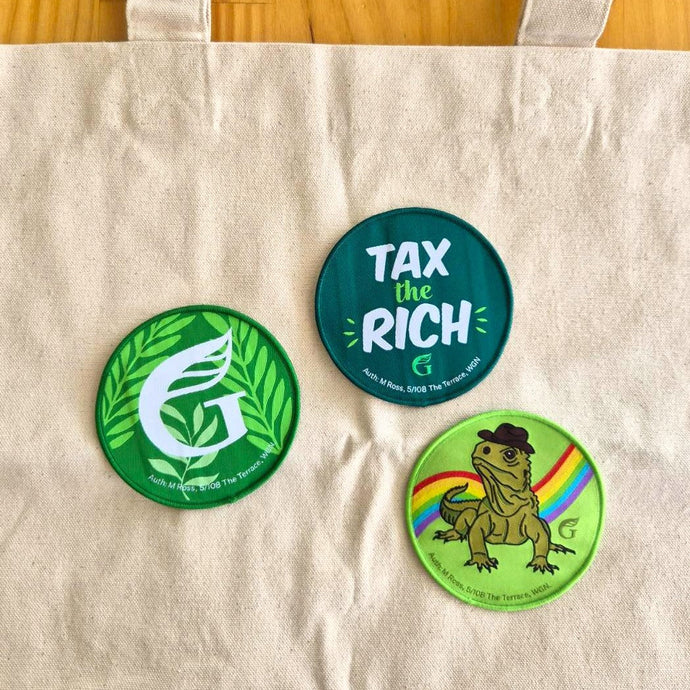 Three woven patches featuring three designs: a Green logo with leaves, a Tax the Rich slogan, and a Tuatara with a rainbow in the background. 